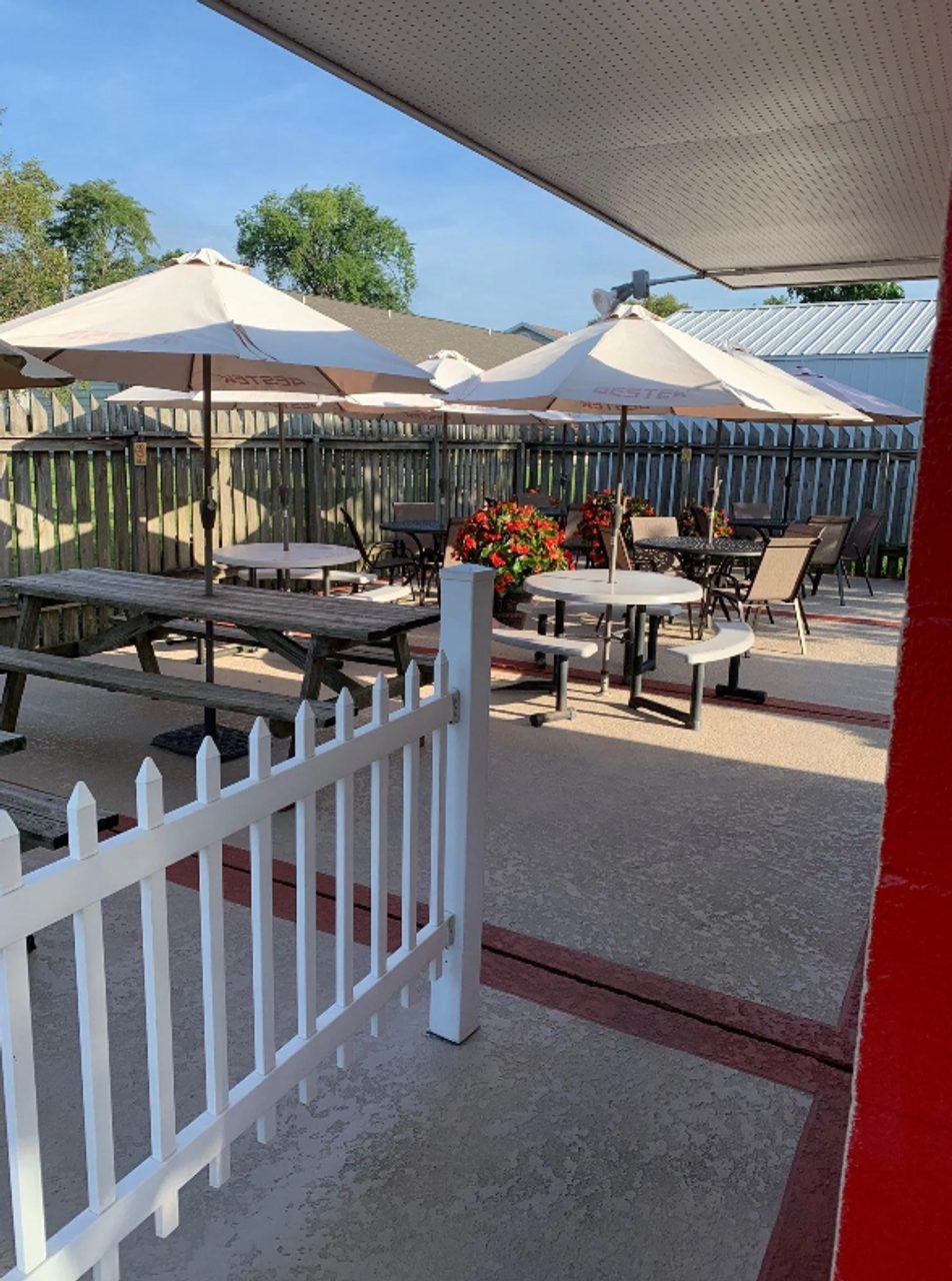 Cruiser's patio behind the white fence with umbrellas